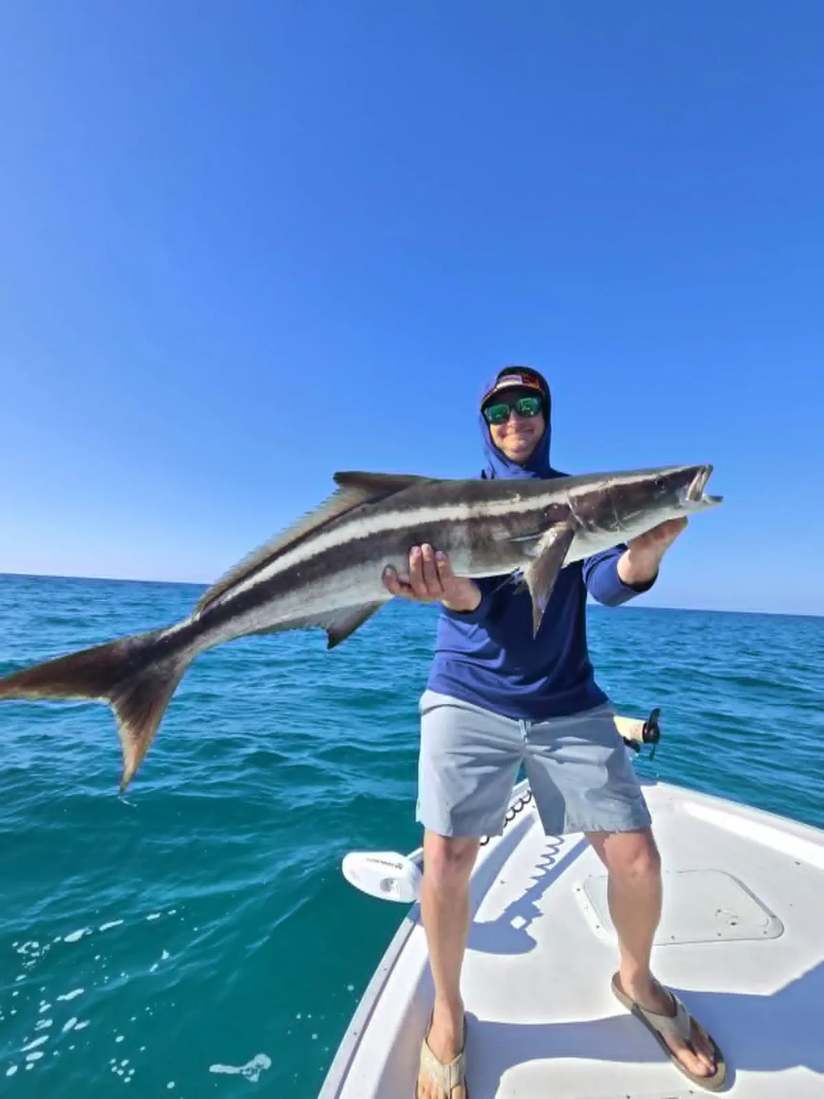 Captain Marvin Glasgow holding a cobia during a 30A fishing charter