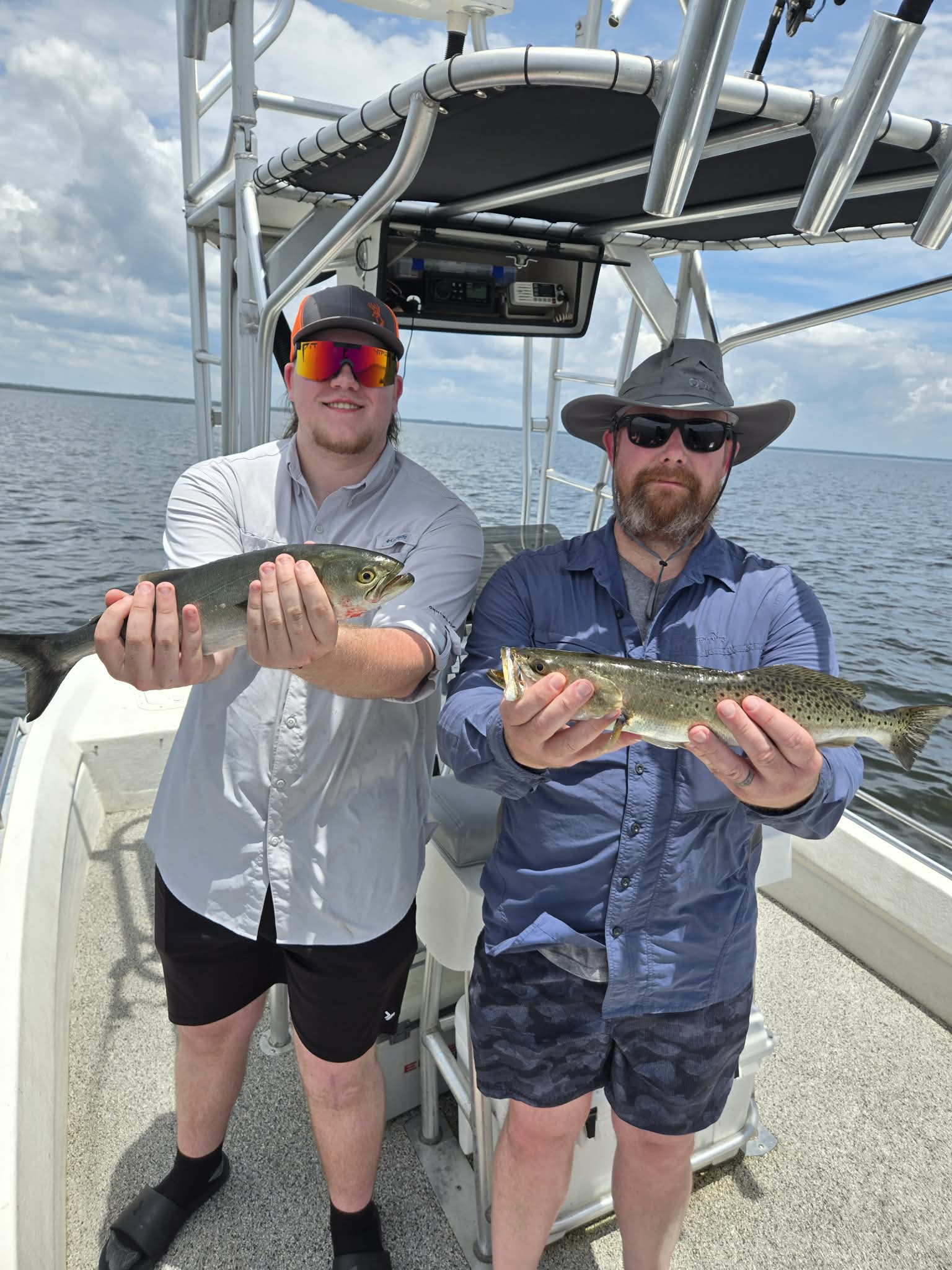 Guest smiling with a speckled trout caught on a 30A fishing charter