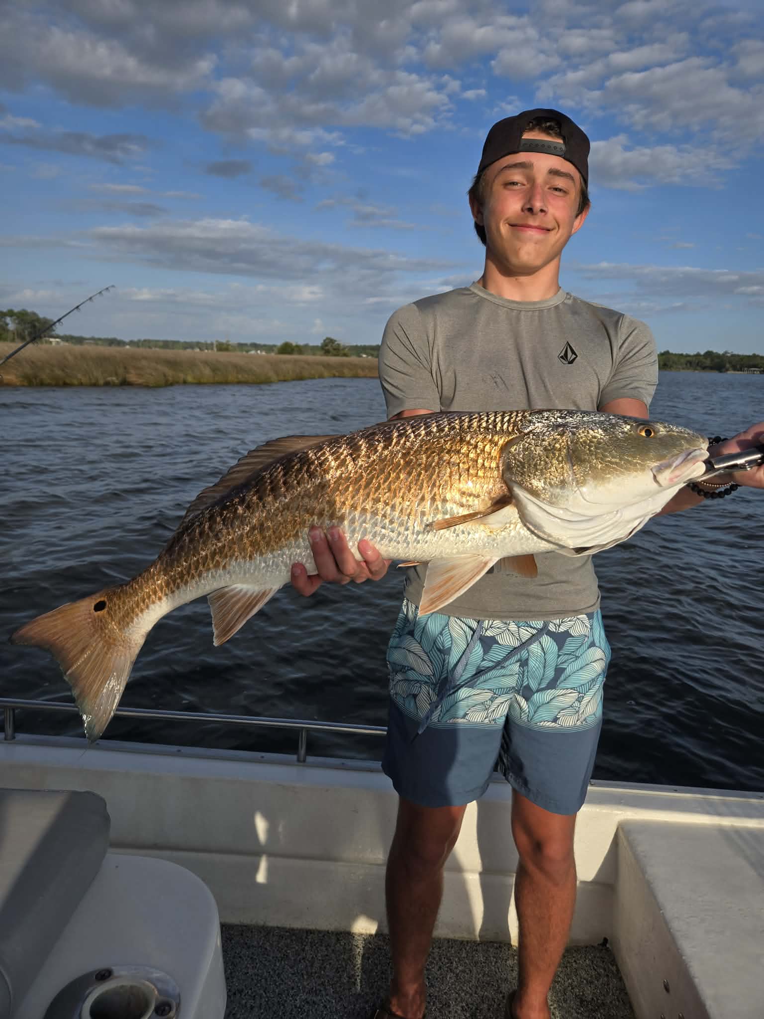 Young angler showing a catch aboard the 30A Bay Guide Service boat