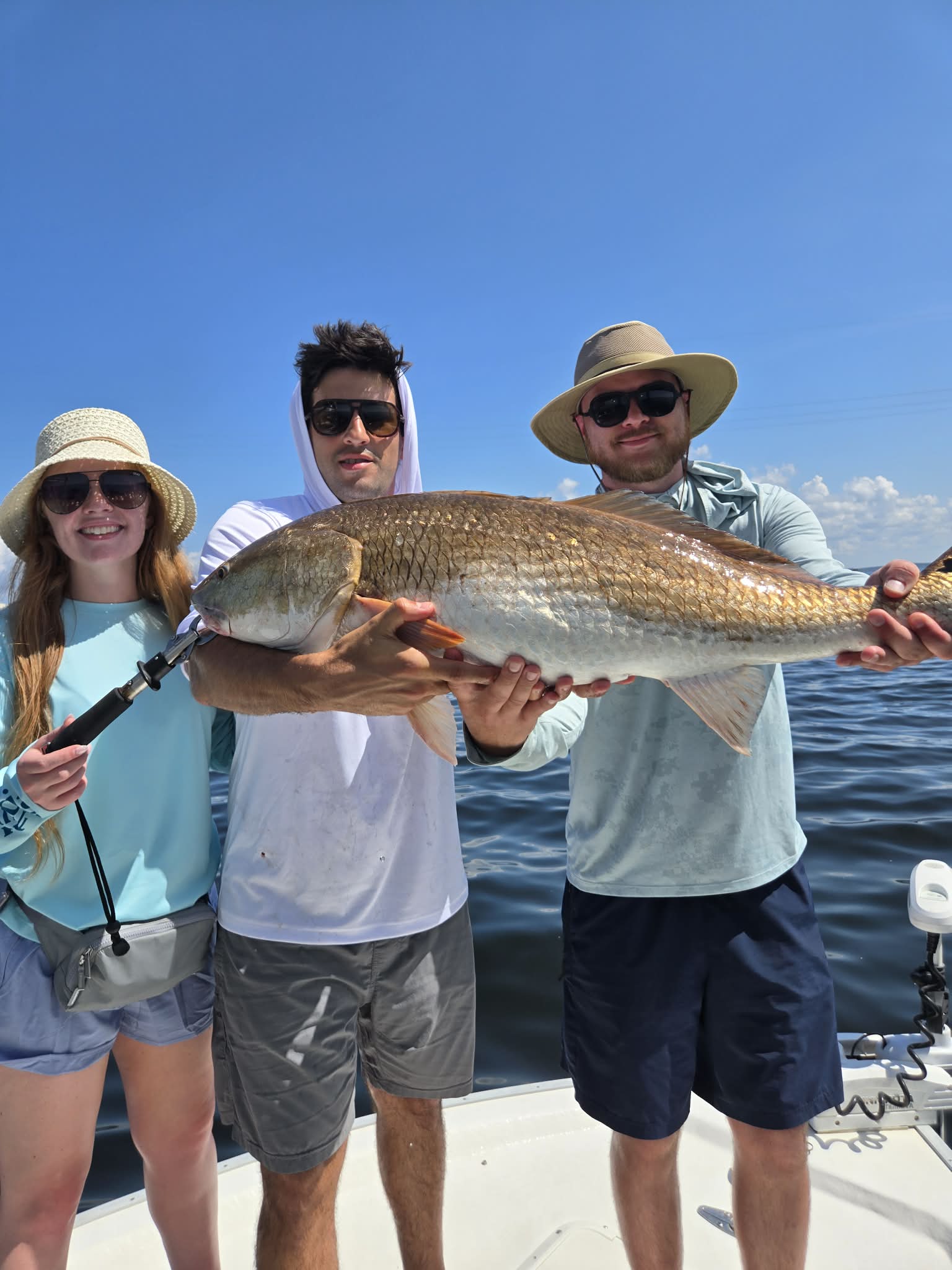 Young angler holding a shark on the boat
