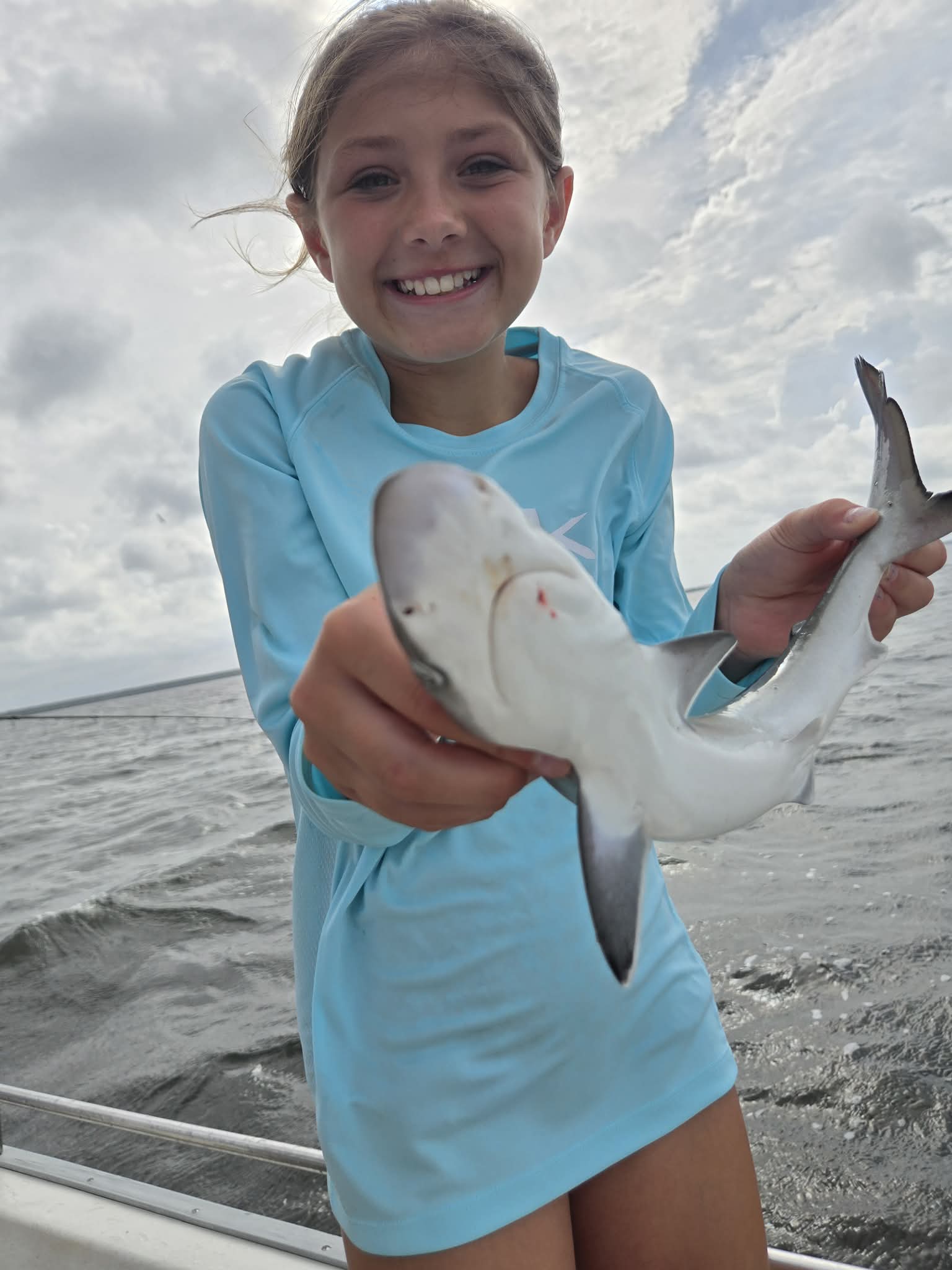 Young angler holding a shark during a 30A shark fishing trip
