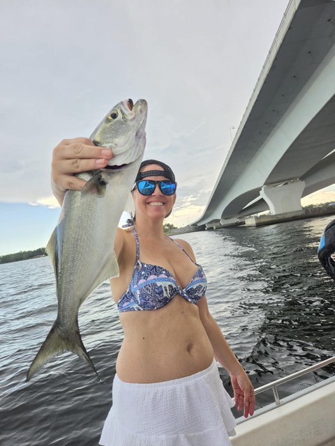Guest smiling with an inshore catch aboard Captain Marvin’s boat