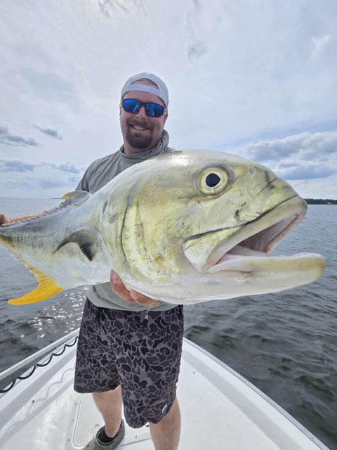 Guest holding a speckled trout during an inshore fishing charter