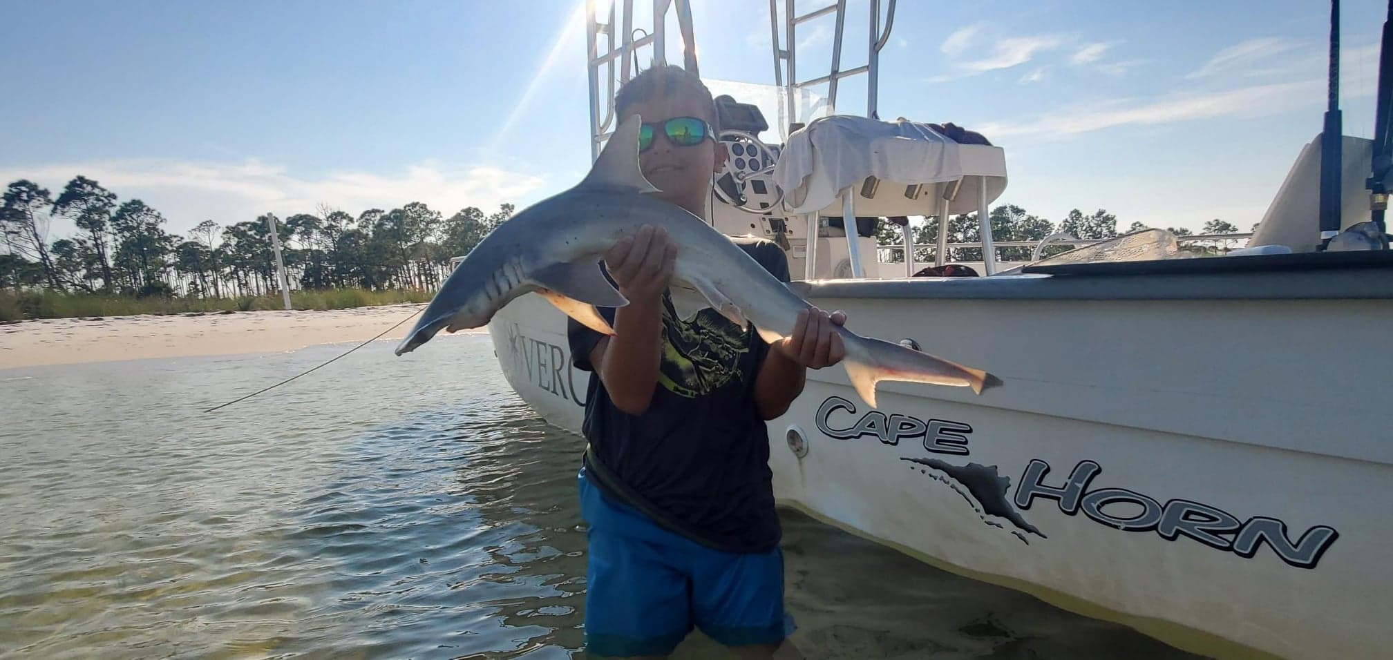 Young angler holding a shark on a private 30A fishing charter